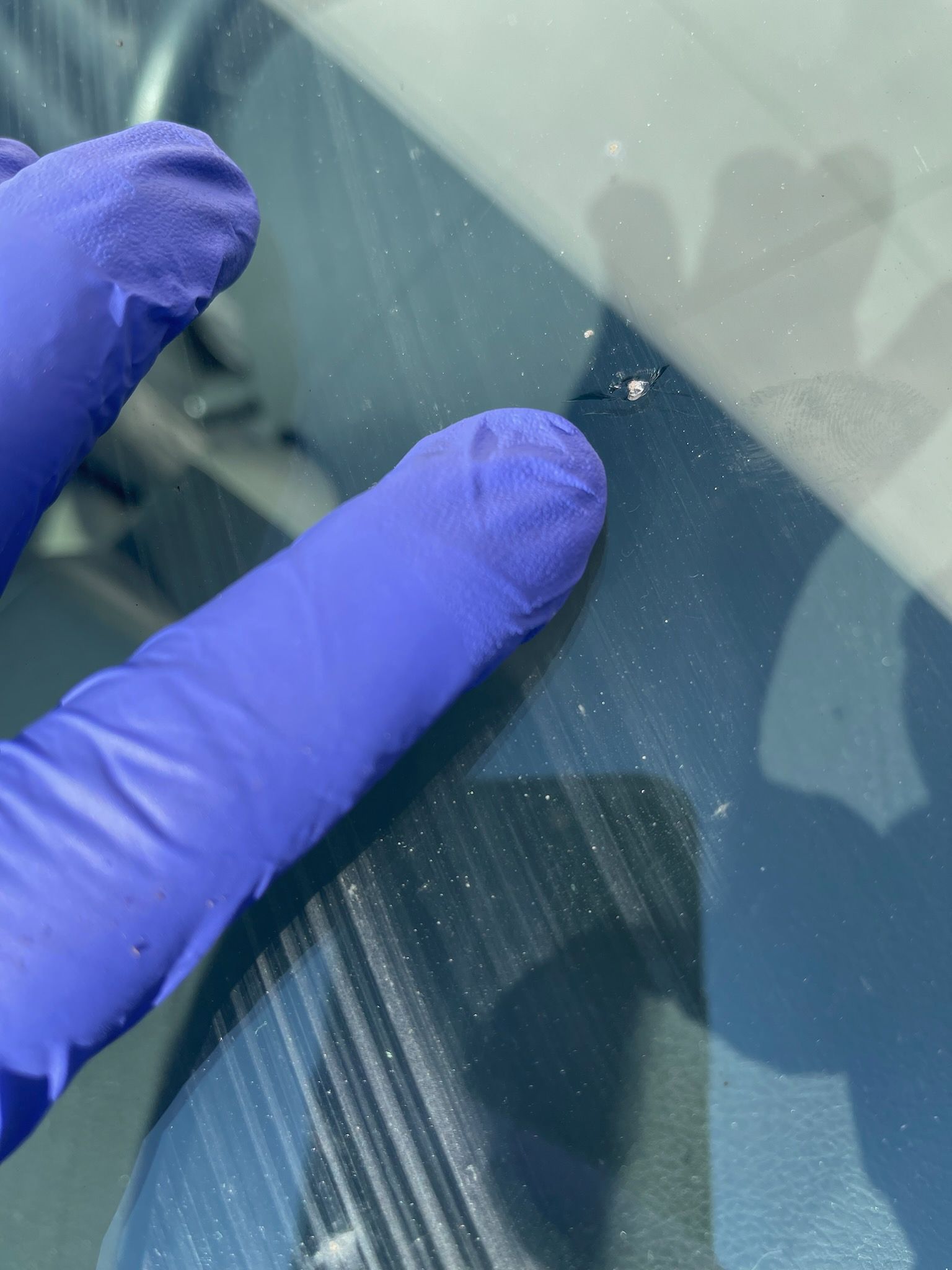 Rock chip damage on windshield being inspected by Mission Auto Glass technician in Charleston