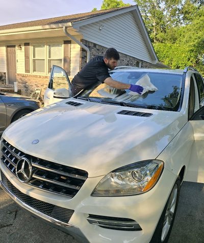 Mission Auto Glass technician performing windshield repair on a Mercedes-Benz at a James Island residence