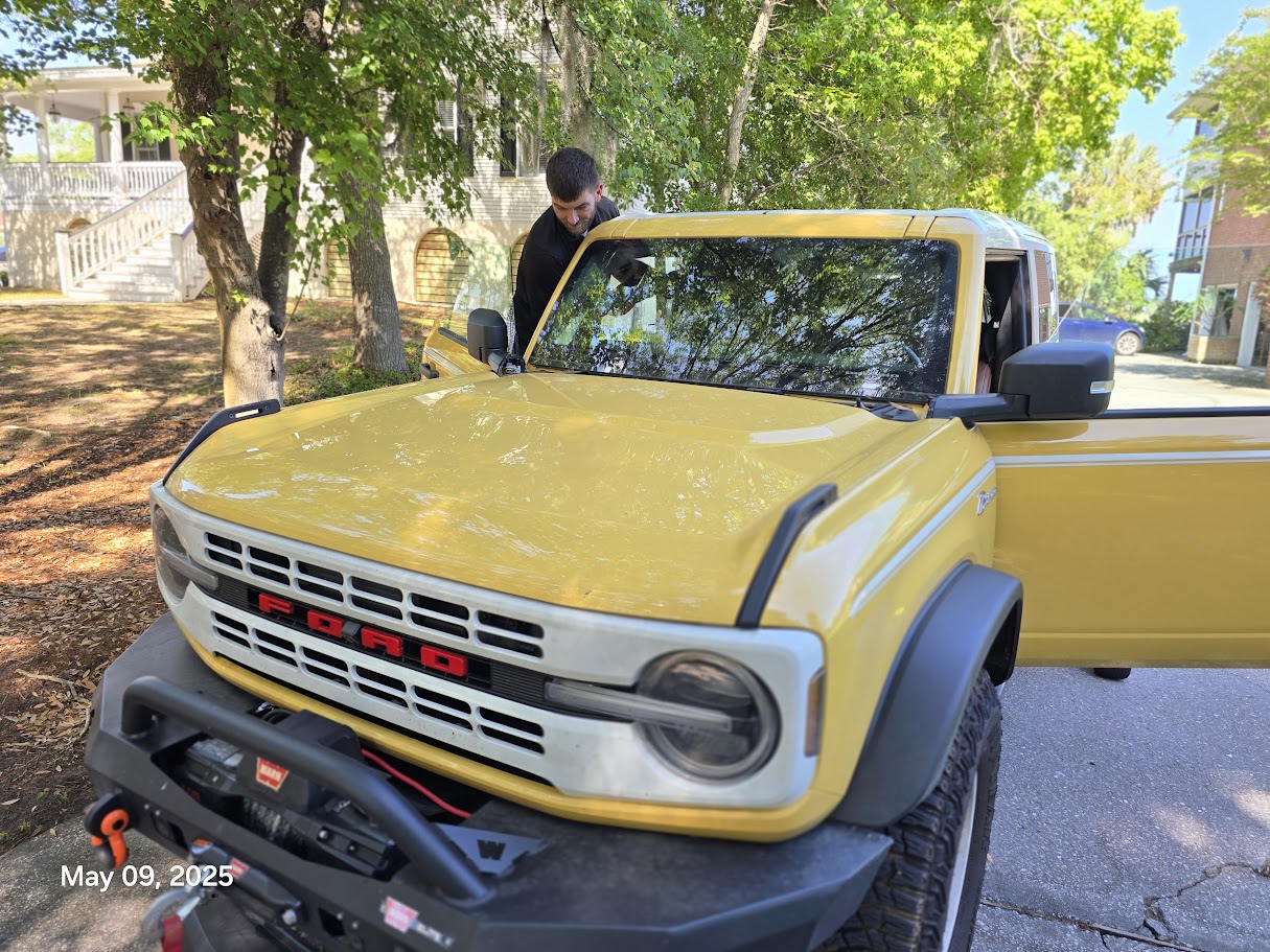 Windshield installation on yellow Ford Bronco under live oak trees in Charleston SC